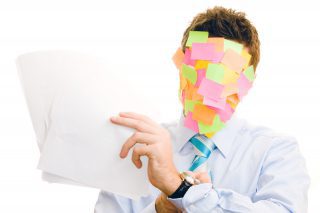 Beschäftigter Arbeitnehmer mit Post-Its im Gesicht