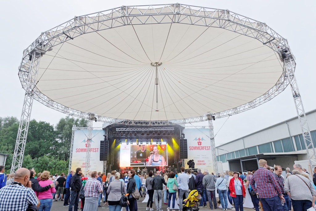 Unmittelbar vor der Hauptbühne beim Windmöller&Hölscher-Sommerfest 2017 war als Regen- und Sonnenschutz ein Skyliner Überdachungssystem mit 22 Metern Durchmesser errichtet worden.