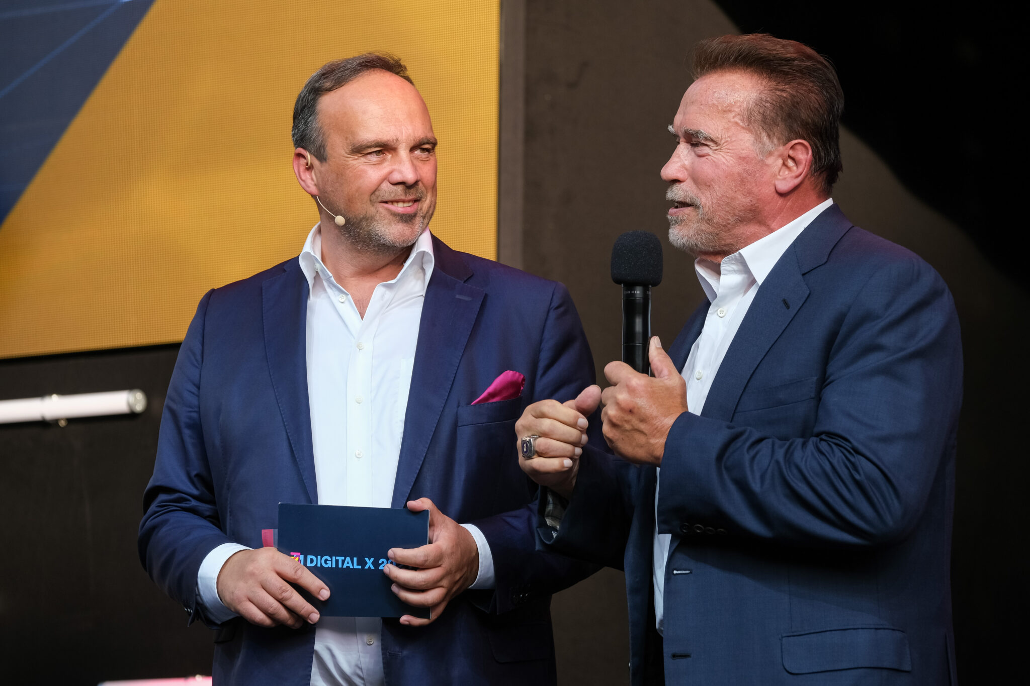 Digital x 2021: Hagen Rickmann, Schirmherr der Digital X und Geschäftsführer Geschäftskunden Telekom Deutschland GmbH, zusammen mit Arnold Schwarzenegger (r.)