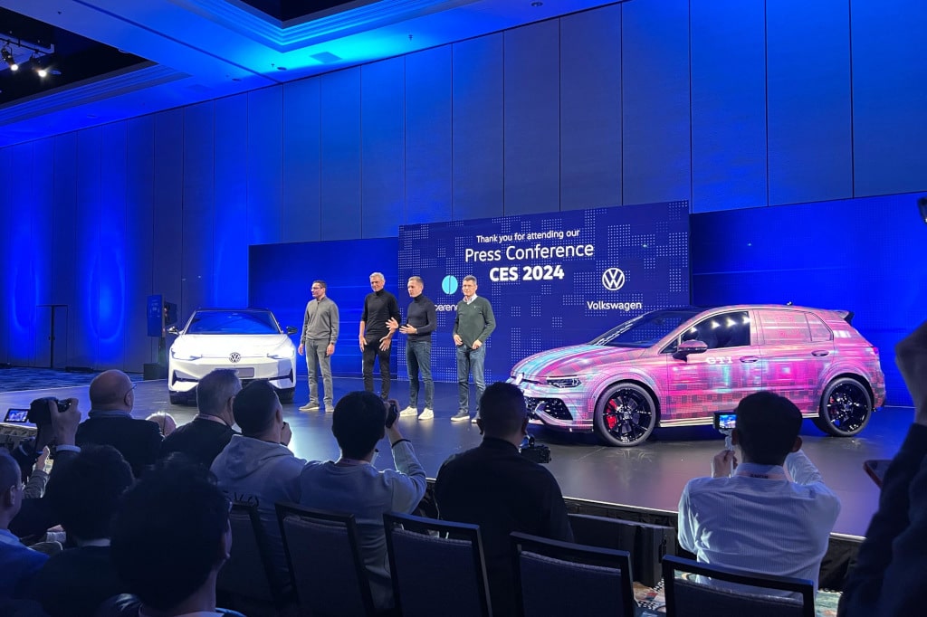 Zwei Volkswagen-PKW und Personen auf der Bühne der CES 2024 in Las Vegas