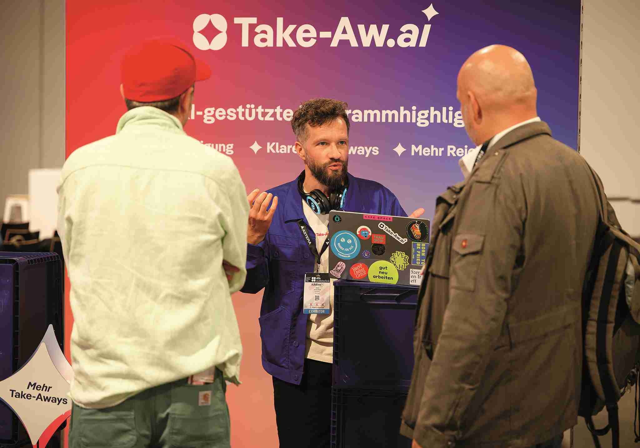 Rönke von Take-Aw.ai erklärt interessierten Besuchern, wie sich das interaktive KI-Tool für Veranstaltungen einsetzen lässt.